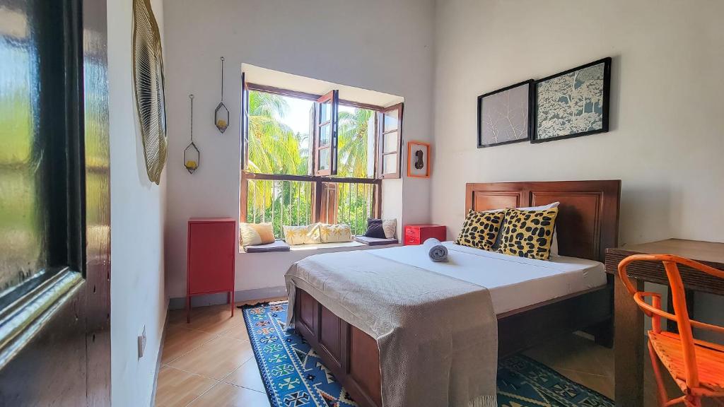sypialnia z łóżkiem i oknem w obiekcie Tarawanda House by Stawi w mieście Stone Town