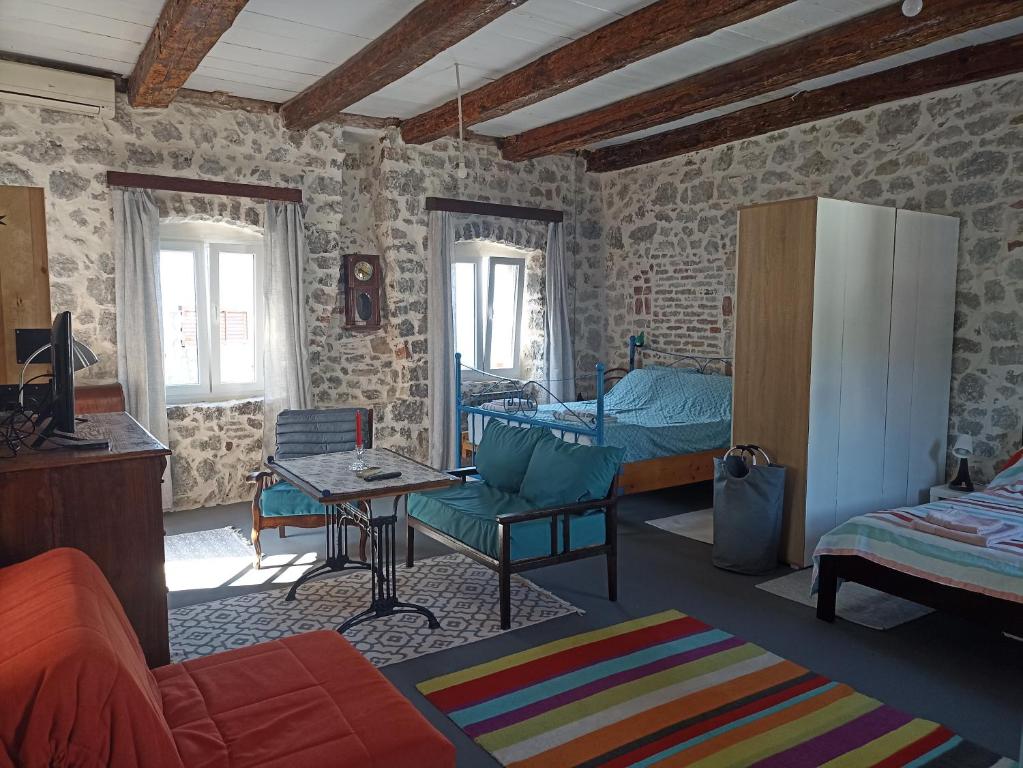 salon z kanapą, łóżkiem i stołem w obiekcie 19th century stone house on the seashore w mieście Radovići