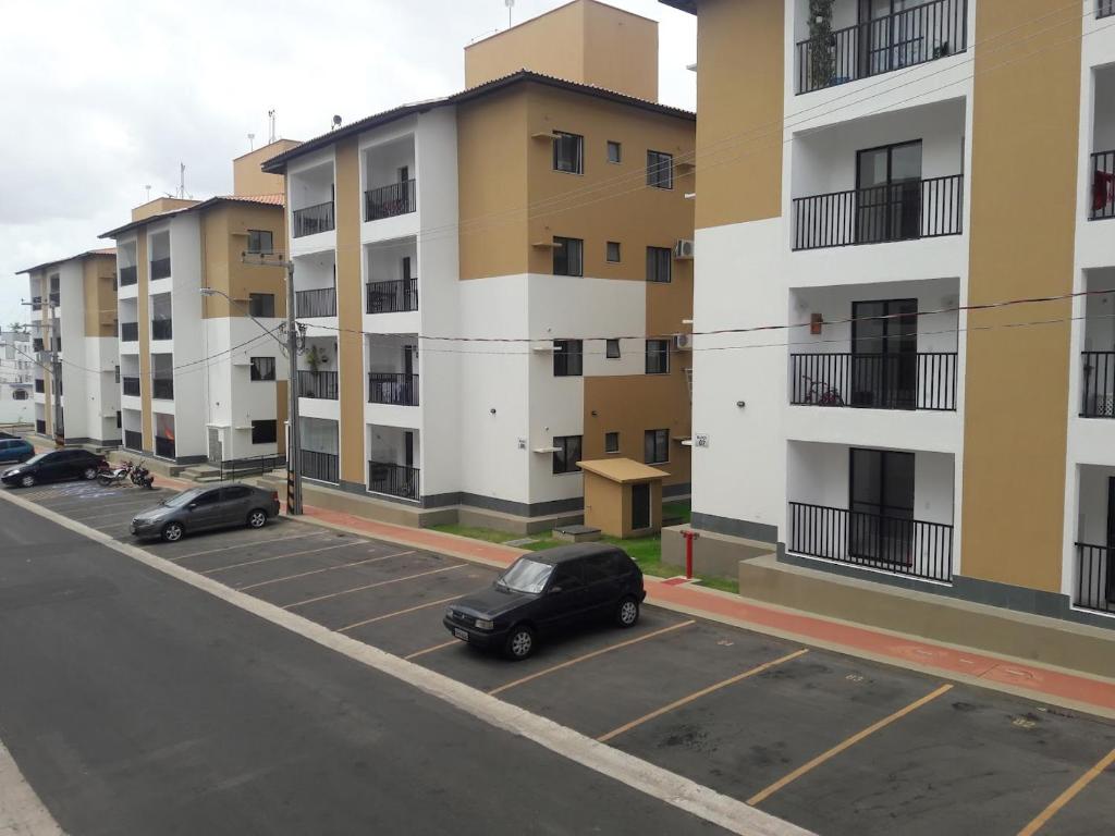 dos coches estacionados en un estacionamiento frente a los edificios de apartamentos en Flat no Turu, en São Luís