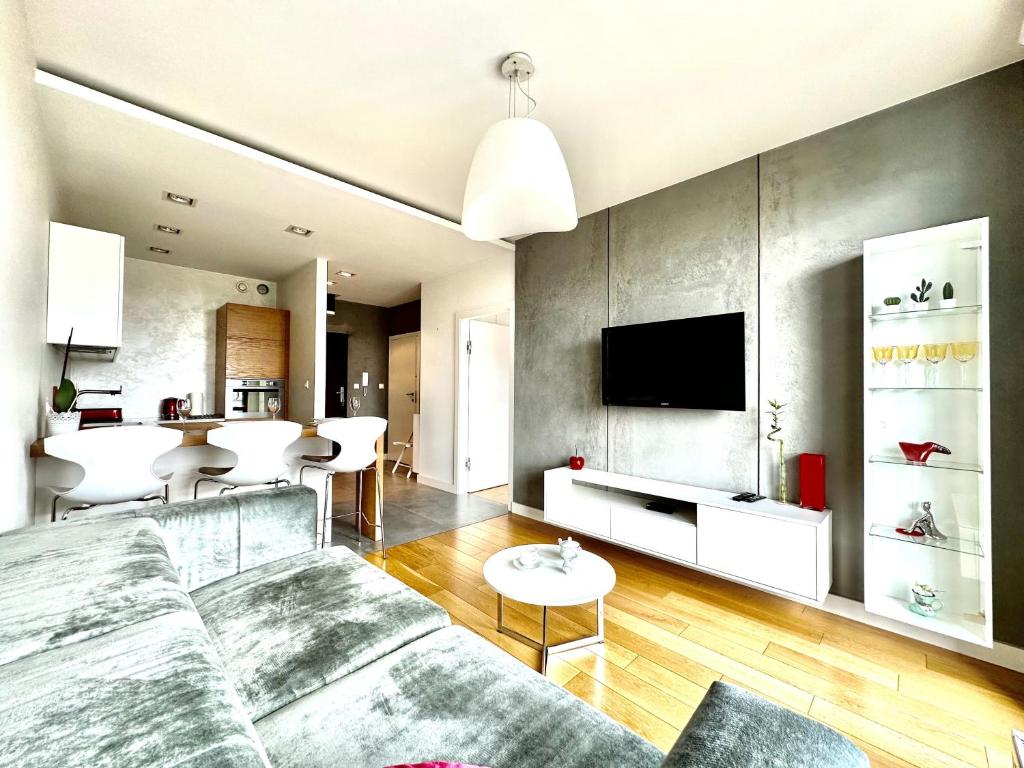 uma sala de estar com um sofá e uma televisão em PODWALE 2 Apartment - Self Check-In 20h ~Parking & Lift em Breslávia