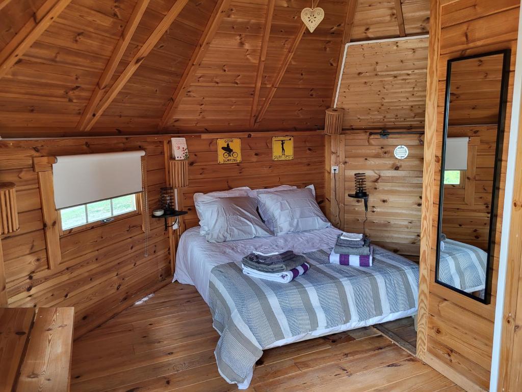 une chambre avec un lit dans une cabane en bois dans l'établissement Le Hameau Saint-Julien, à Engayrac