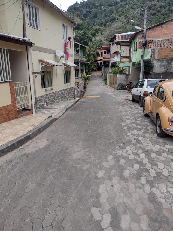 an empty street with cars parked next to buildings at Casa no Centro em DM - 500 metros rua de lazer in Domingos Martins