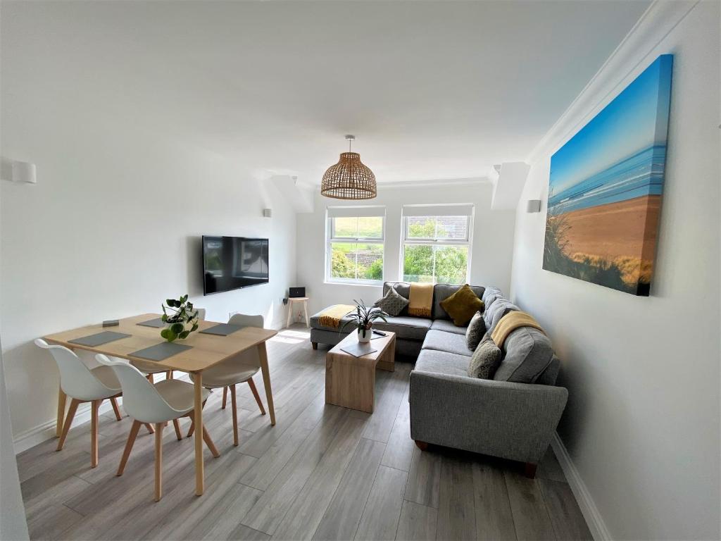 a living room with a couch and a table at Surfside in Woolacombe