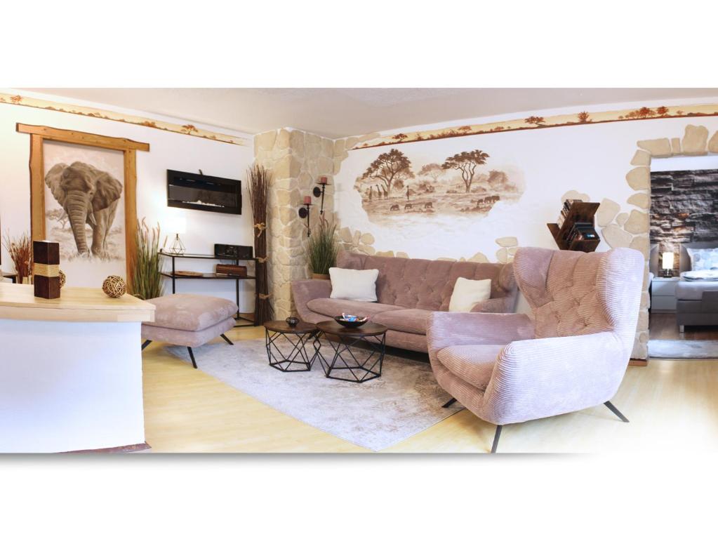 a living room with two couches and an elephant mural at Ferienwohnung Belasarte in Bad Elster