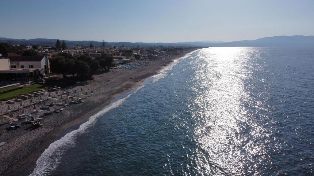 una vista aérea de una playa con sombrillas y agua en Stamatakis Boutique Studios, en Plataniás