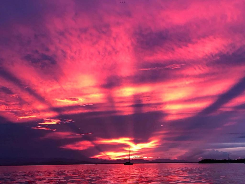 una puesta de sol sobre el agua con un cielo rojo en Life is Good, en Bocas Town