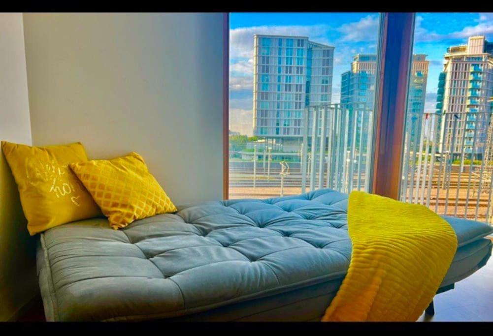 a blue couch with yellow pillows in front of a window at Sunset Apartment Vienna in Vienna