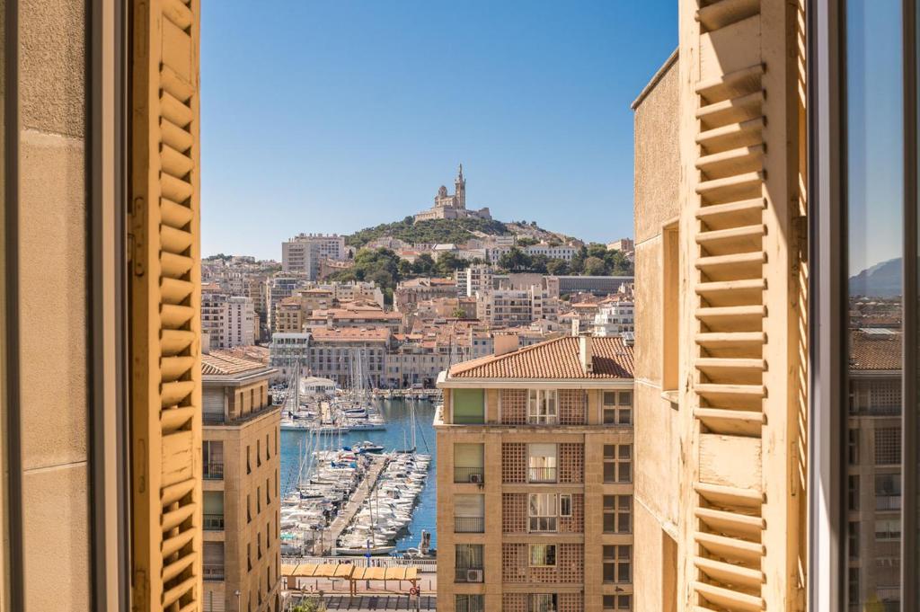 uma vista a partir de uma janela de uma cidade com um porto em Splendide vue sur ND de la Garde et le Vieux Port em Marselha