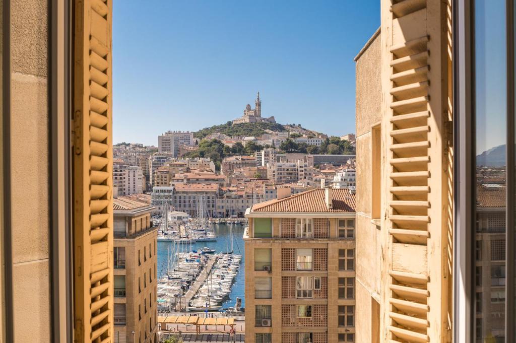 - une vue depuis la fenêtre d'une ville avec un port dans l'établissement Splendide vue sur ND de la Garde et le Vieux Port, à Marseille
