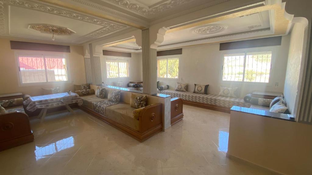 a large living room with couches and windows at Big appartement in ksar sgher and close in Ksar es Sghir