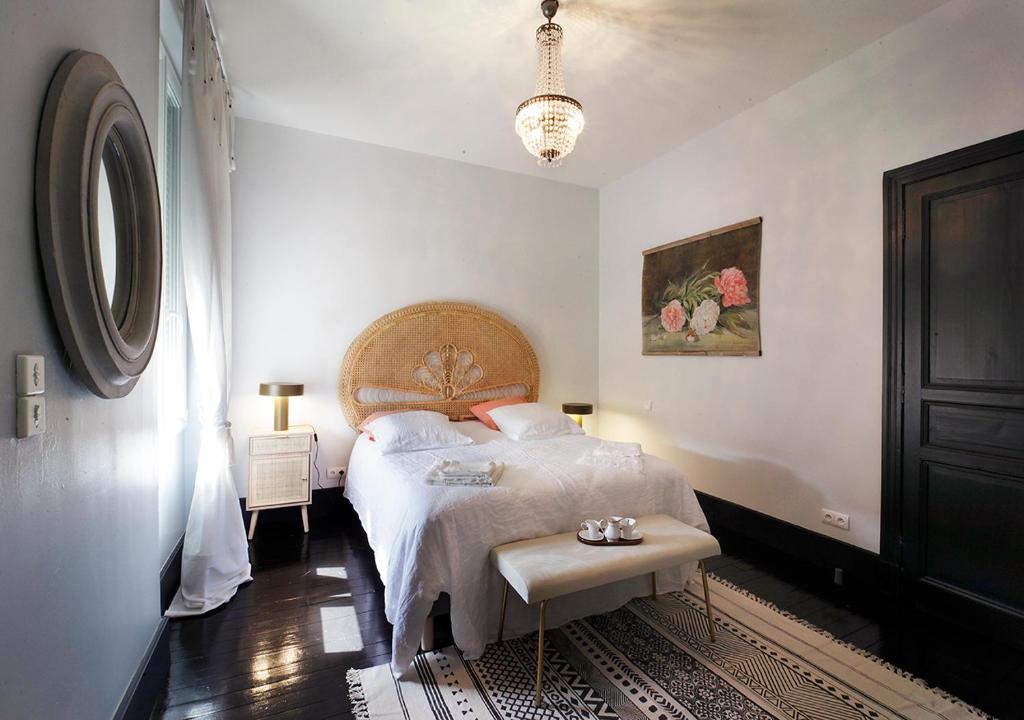 Un dormitorio con una cama y una mesa. en Maison d'Hôtes " L'INSTANT D'AILLEURS", en Albi