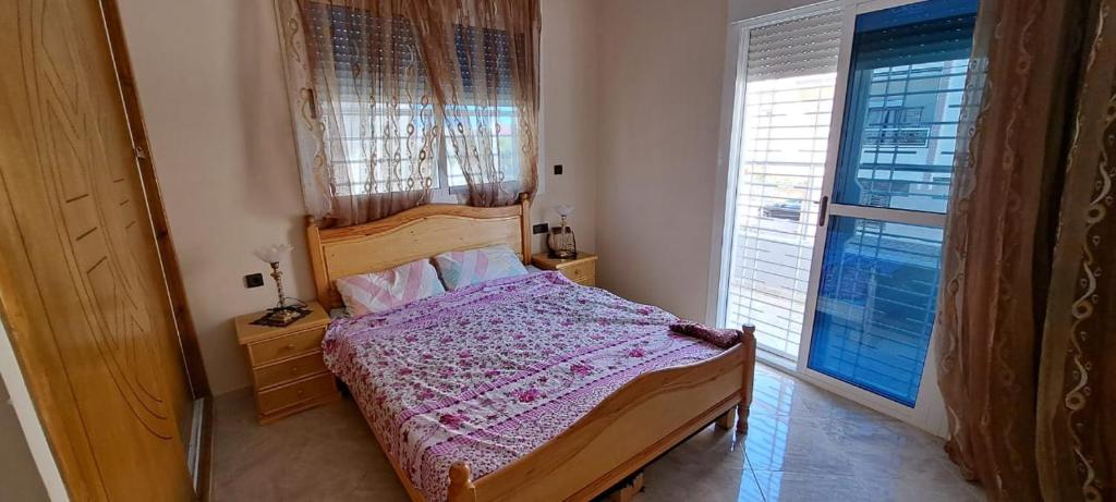 - une chambre avec un lit et une grande fenêtre dans l'établissement appartement à louer saidia, à Saïdia