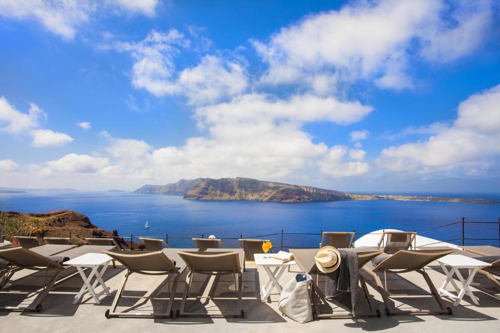 un patio con sillas y vistas al océano en Esperas en Oia