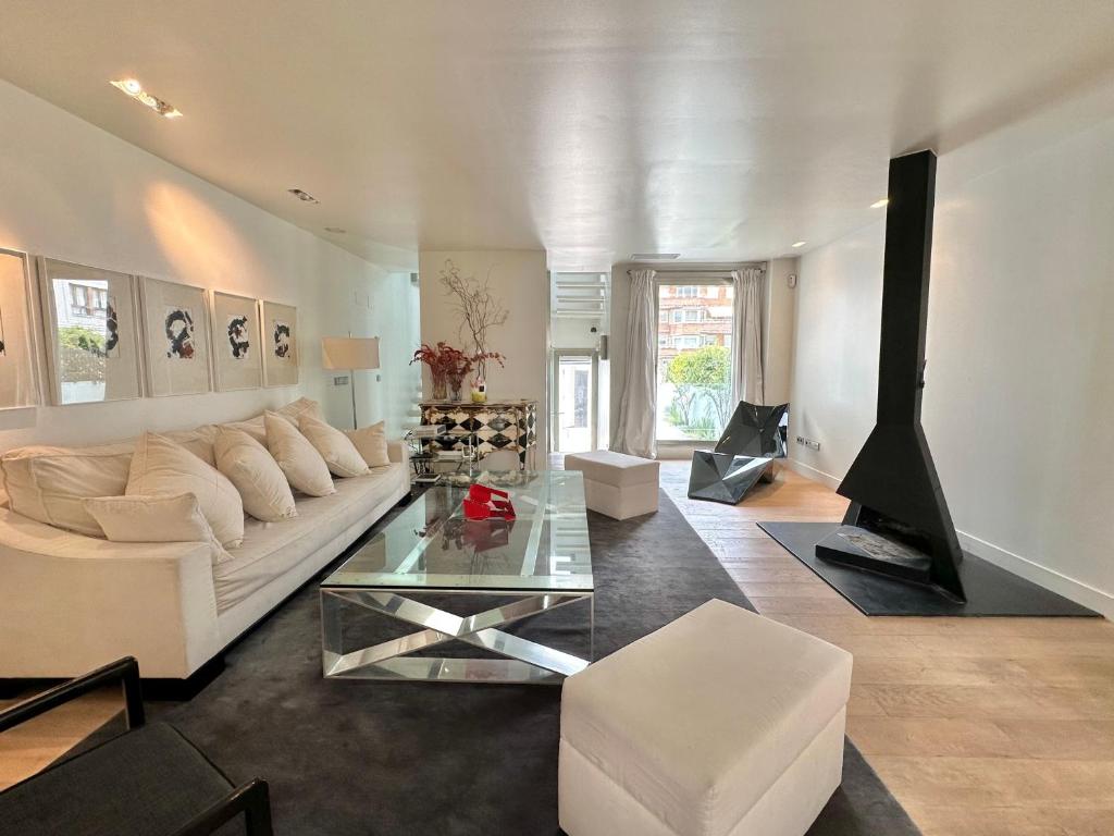 a living room with a white couch and a fireplace at Villa Don Juan in San Sebastián