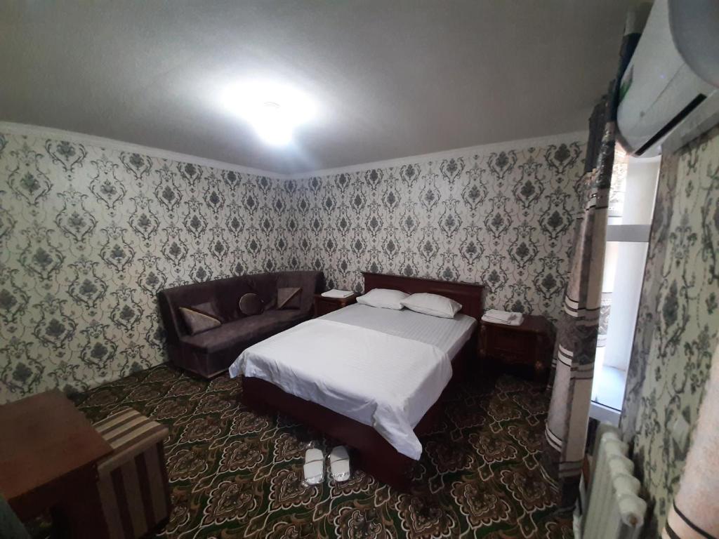 una camera con letto e divano di Dilnura Guest House a Bukhara