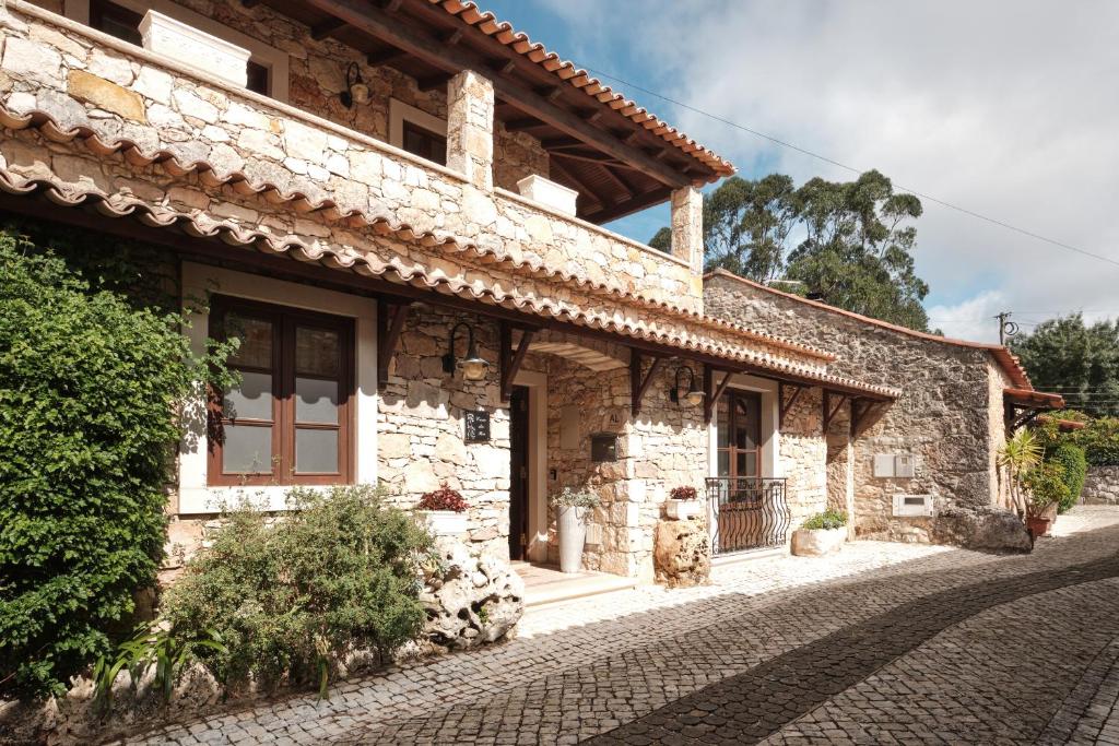 a stone house on a cobblestone street at CASA DA PIA - Pia do Urso in Casais de São Mamede