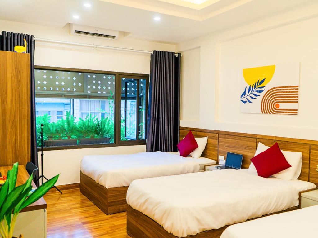 twee bedden in een kamer met een raam bij Bai Chay Panda Hotel in Ha Long