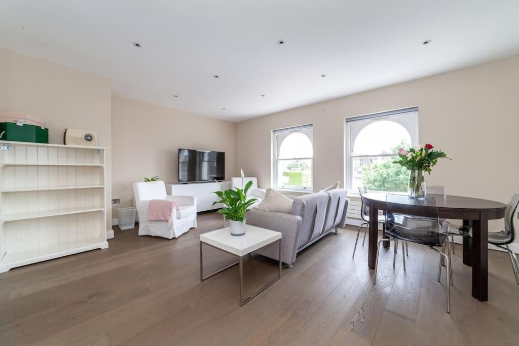 uma sala de estar com um sofá e uma mesa em Spacious Modern One Bedroom Flat in Chelsea em Londres