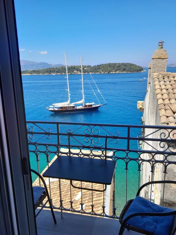 a balcony with a view of a boat in the water at City walls sea view in Corfu Town