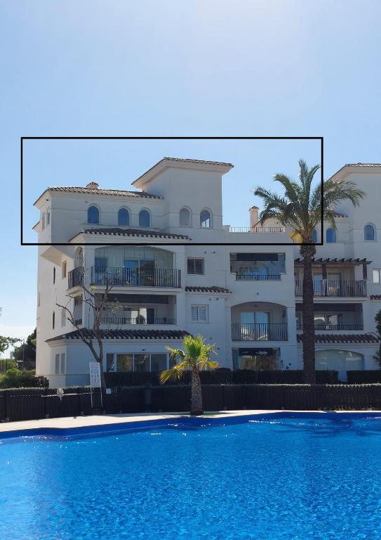 a large white building with a swimming pool in front of it at La Casa Mima Penthouse at Hacienda Riquelme in Sucina