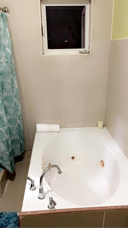 a white bath tub in a bathroom with a window at Luxury one bed room apartment in Nassau