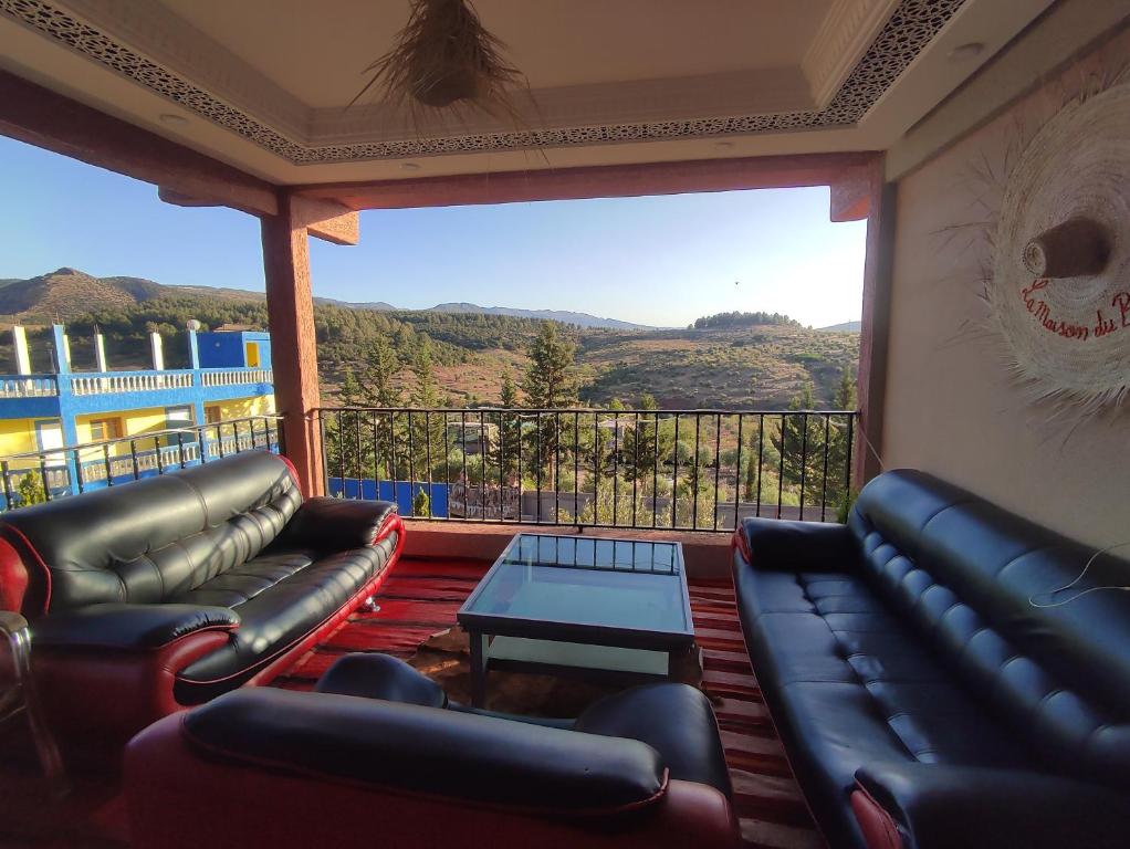 a living room with leather furniture and a large window at La belle vue Elmazini in Demnat