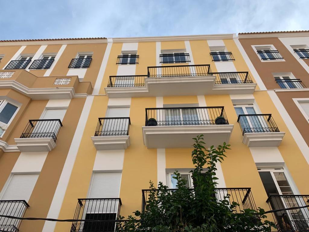 ein hohes gelbes Gebäude mit Balkonen in der Unterkunft Brilliant sea apartment in Villajoyosa