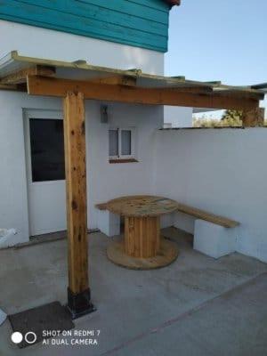 a wooden picnic table in front of a building at La pinza mor in El Palmar