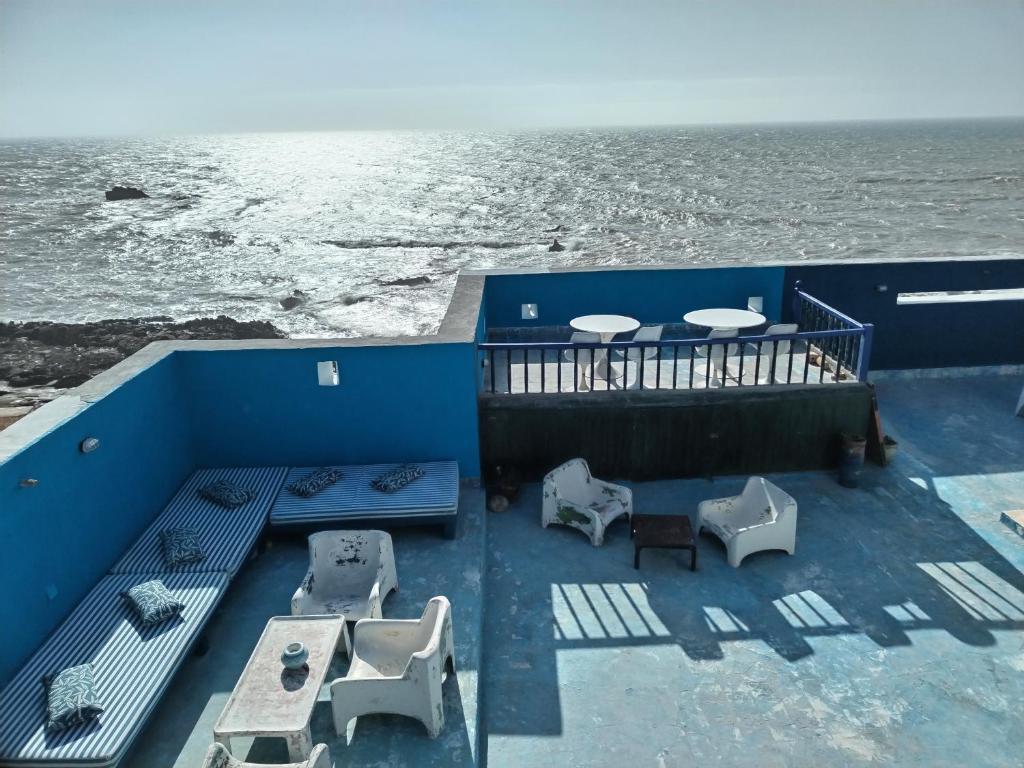 einen Balkon mit Tischen, Stühlen und Meerblick in der Unterkunft La Maison des Artistes in Essaouira