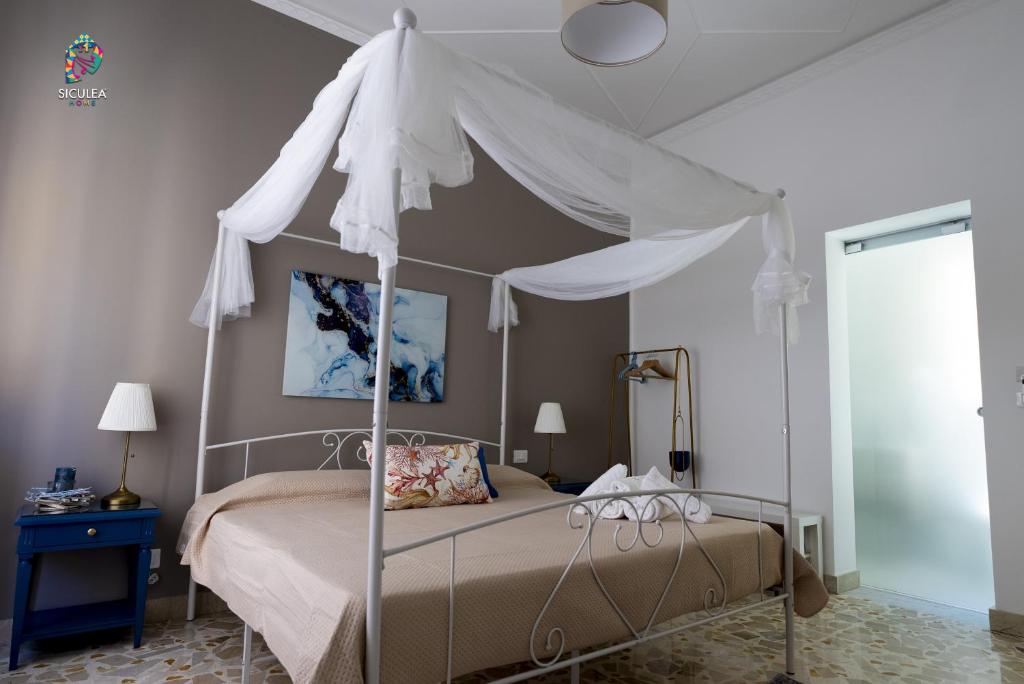 a bedroom with a bed with a canopy at Siculea Home in Adrano