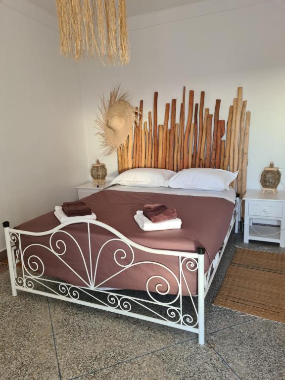a bed with a wooden headboard in a bedroom at La Maison des Vagues in Sidi Kaouki