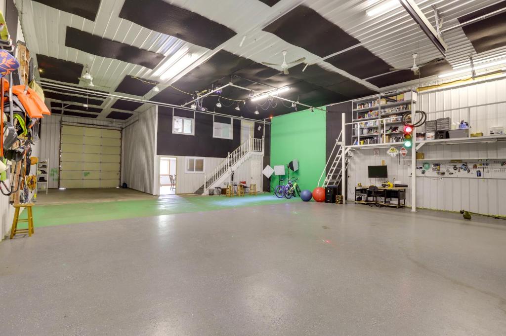 un garage vide avec une pièce avec un mur vert dans l'établissement Unique Lawrence Escape with WFH-Friendly Workspace, 