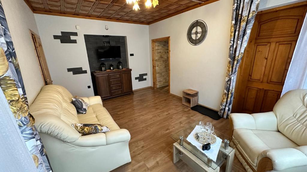 ein Wohnzimmer mit 2 Sofas und einem TV in der Unterkunft Apartament Władek in Biały Dunajec