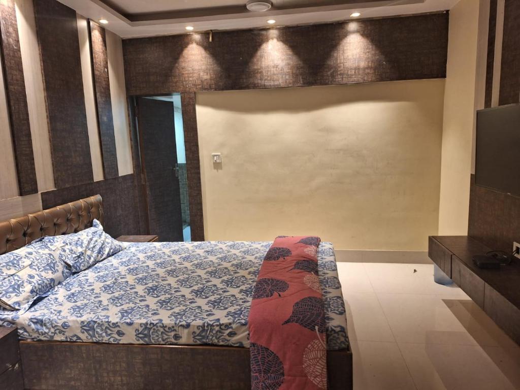 a bedroom with a bed and a flat screen tv at Mavenoak Dreams B&B in Kolkata