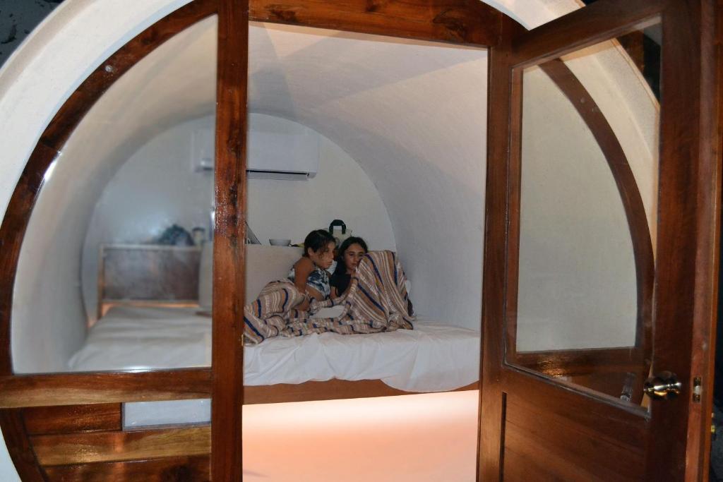 two children sitting on a bed in a room at Kakao Cobá Hotel & Cenote Experience in Cobá
