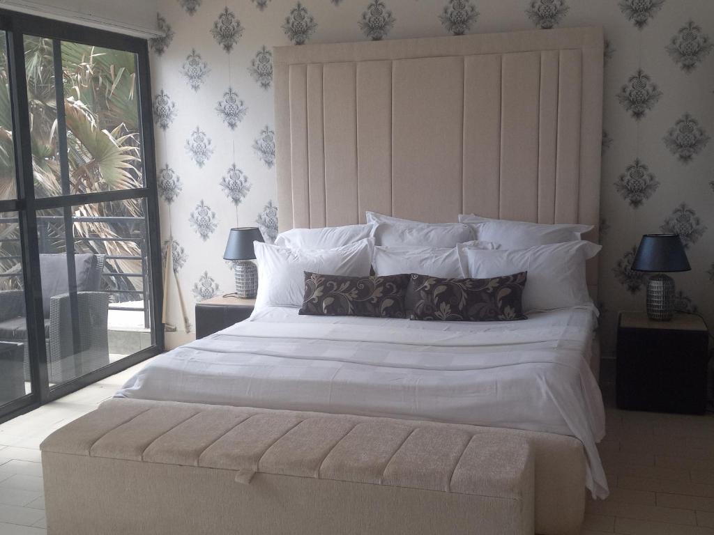 um quarto com uma grande cama branca e uma grande janela em Luxury large 4 bedrooms Beach front house em Sere Kunda