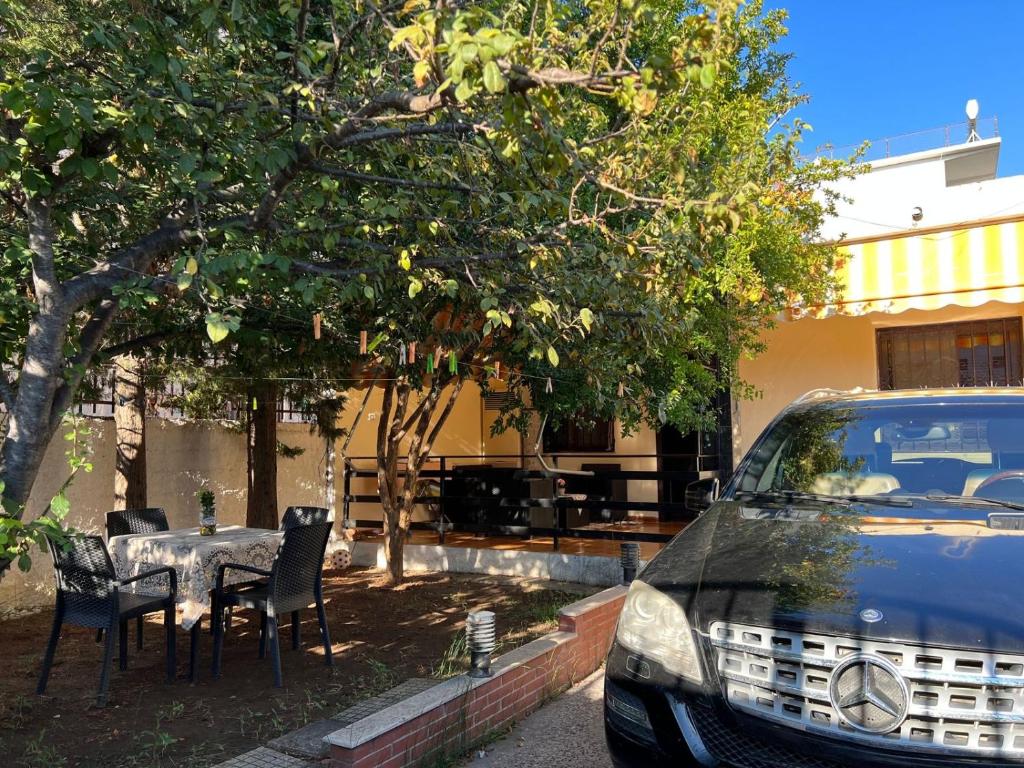 a car parked in front of a house with a table and chairs at Unik Private Villa Center in Velipojë