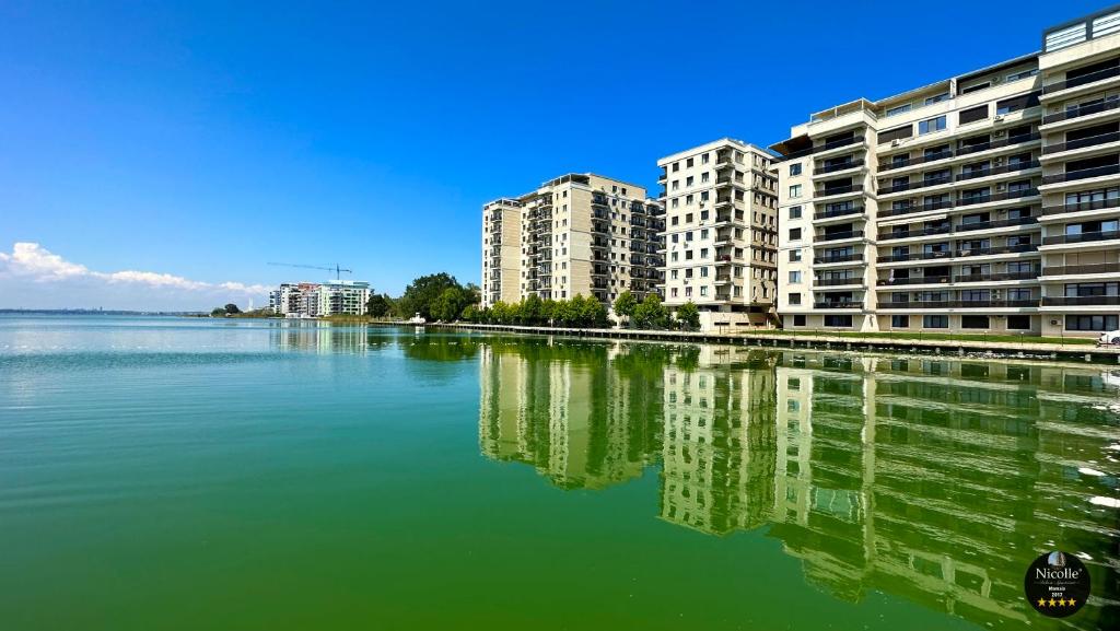 a large body of water with buildings in the background at Deluxe Nicolle Solid Residence Mamaia in Mamaia