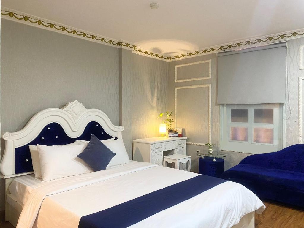 een slaapkamer met een groot bed met een blauw en wit hoofdeinde bij CROWNE BUI VIEN Hotel in Ho Chi Minh-stad