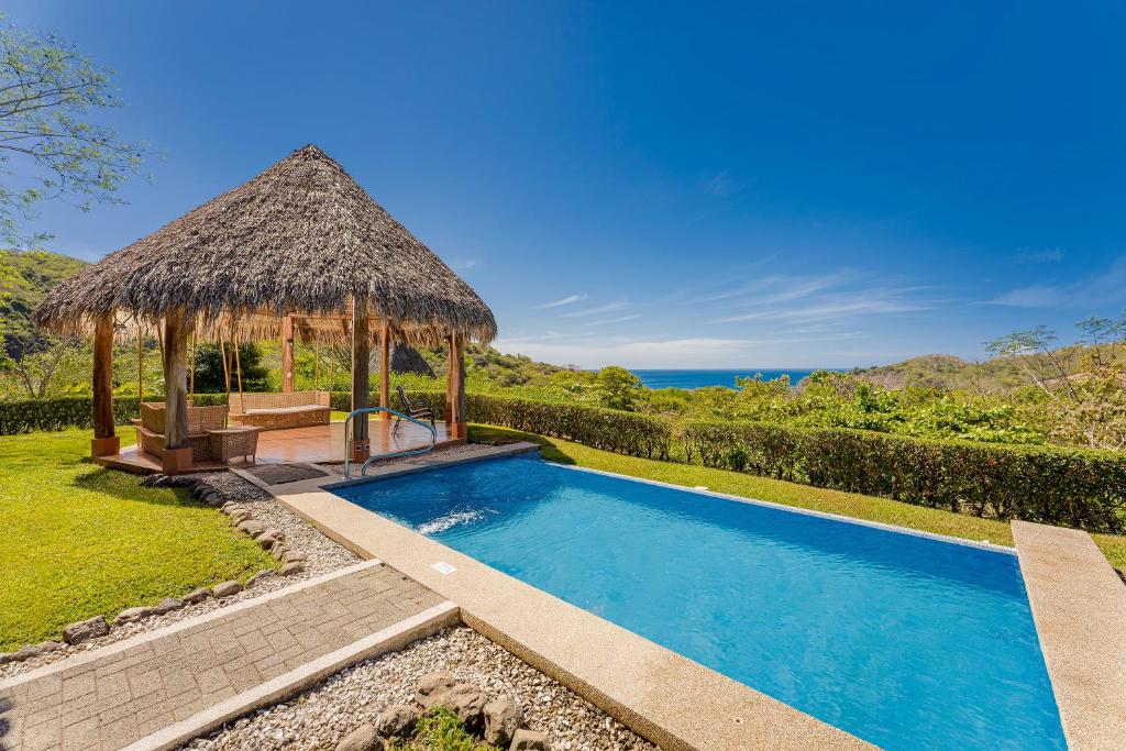 una piscina con cenador y el océano en Punta Islita Villas Luxury Destination, en Islita
