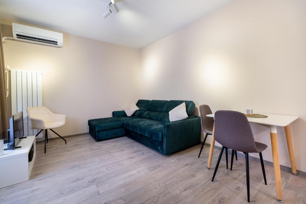 a living room with a green couch and a table at City center 1-Bedroom Apartment in Plovdiv