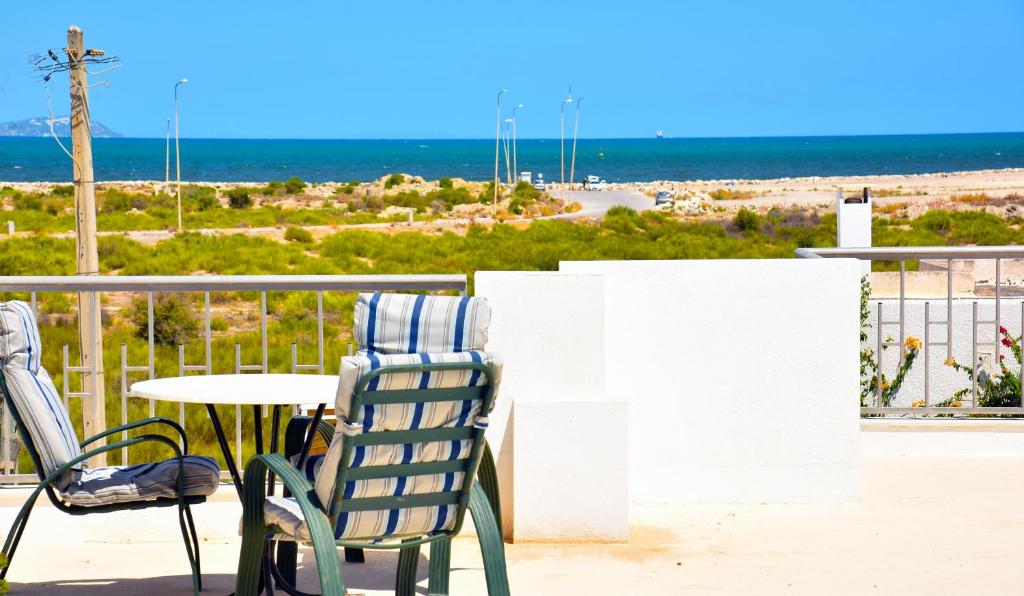 - deux chaises et une table sur un balcon avec vue sur la plage dans l'établissement Appartements neufs et modernes entre ter et mer, à Soliman