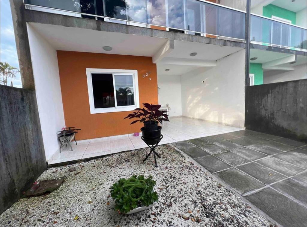 a house with a potted plant in the courtyard at Residencial Passos in Guaratuba