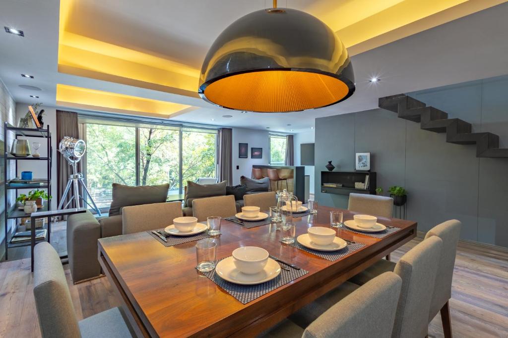 a dining room and living room with a table and chairs at 2floors luxury apartment condesa in Mexico City