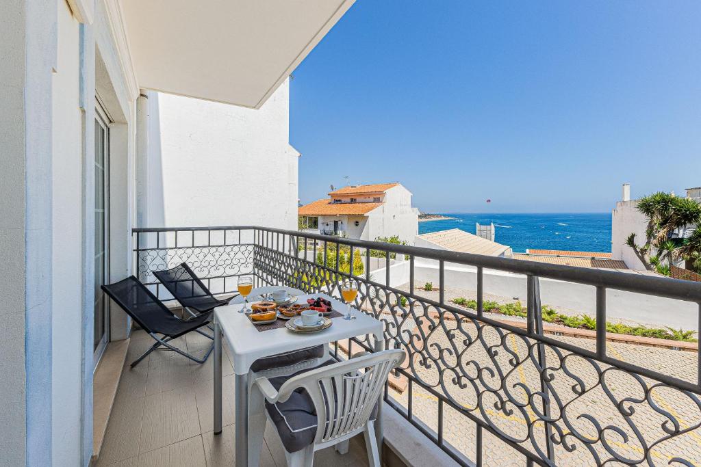 a balcony with a table and chairs and the ocean at Rossio Sea View By ALzira in Albufeira