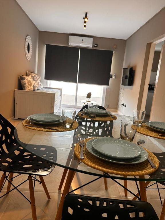 a dining room with a glass table and chairs at DEPTO EN AV ROCA PARA HASTA 4 PERSONAS - Edificio MIRÓ2 in Santiago del Estero