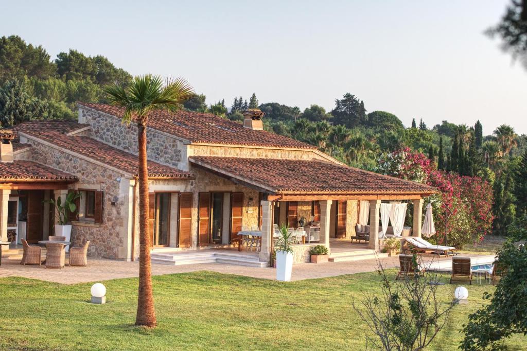 una casa con una palmera delante en Villa Can Figuera, en Alcudia