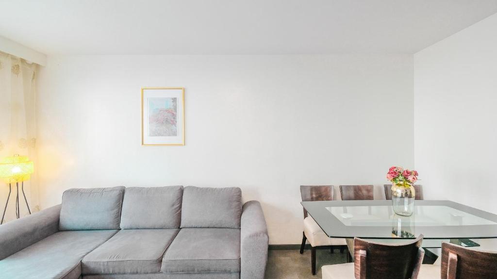 a living room with a couch and a table at Bel Appartement proche Paris 16eme in Boulogne-Billancourt
