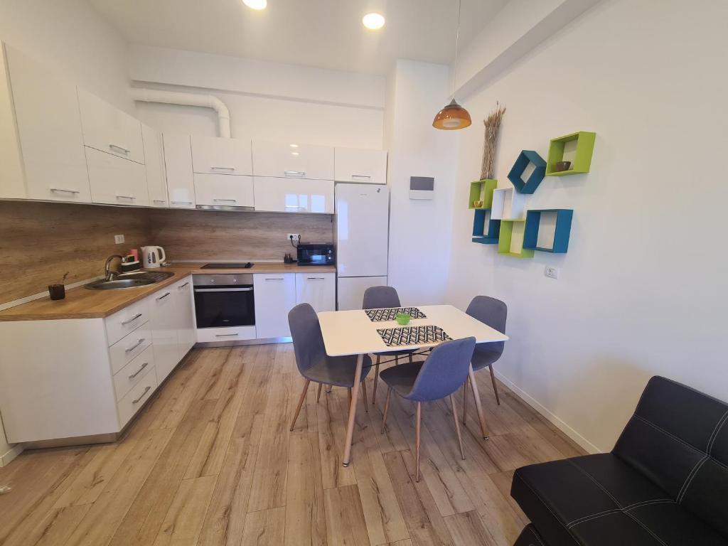 a kitchen and dining room with a table and chairs at Luxury Central Apartment One in Bacău