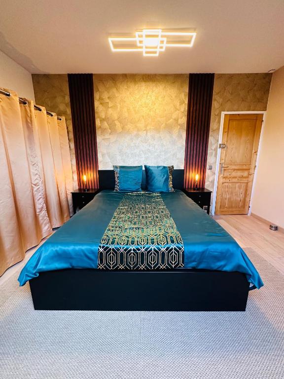 une chambre avec un grand lit bleu avec des oreillers bleus dans l'établissement Jabeen's House Bedroom 1, à Bezons